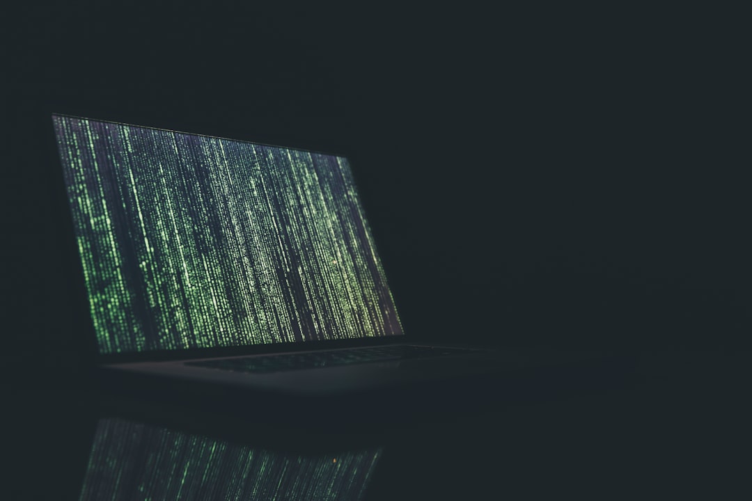 A laptop displaying abstract green and black digital patterns